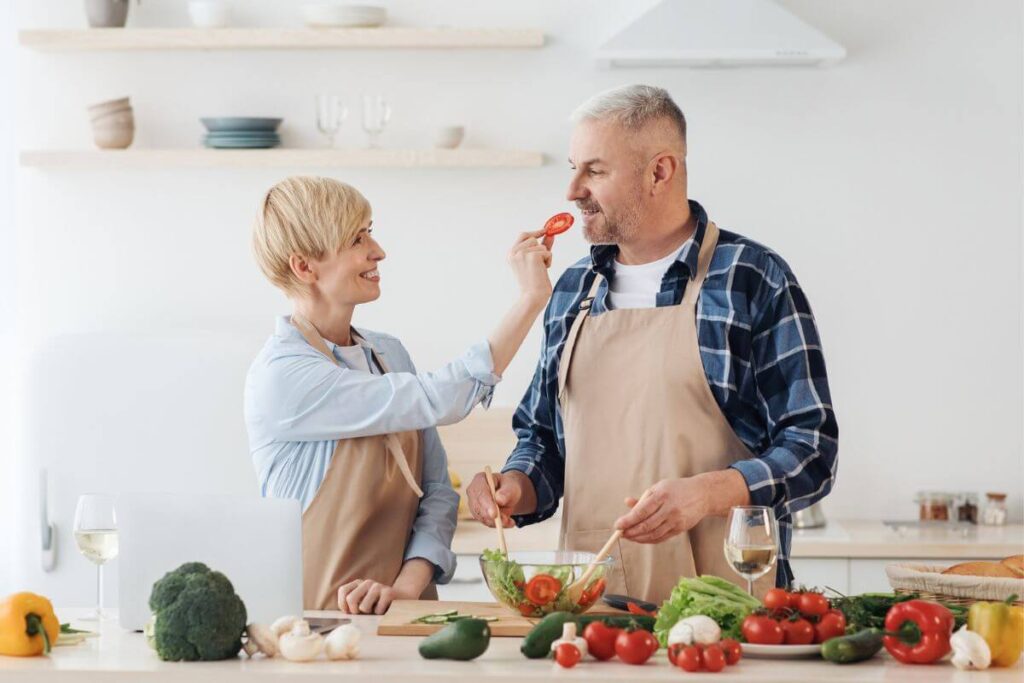 an older couple experiments together with making a delicious salad because she knows personal growth for women over 50 is important