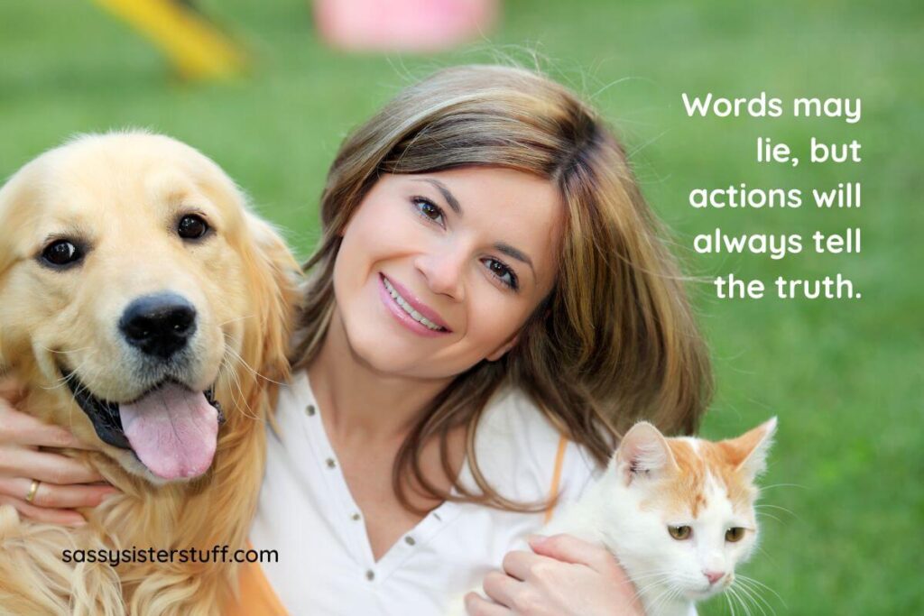 a beautiful woman is cuddling with a happy dog and cat, plus the quote "words may lie, but actions will always tell the truth."