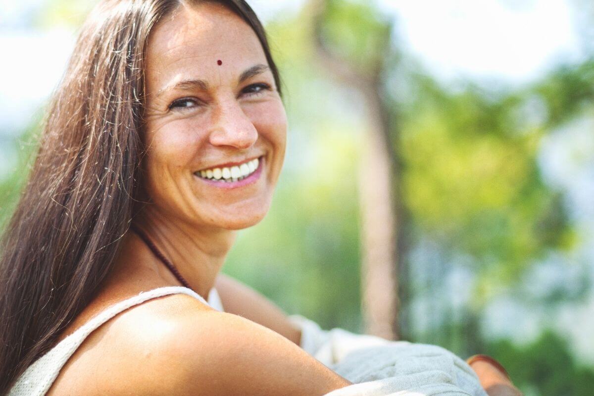 beautiful woman smiles at the camera because she has read buddha quotes on change and has been inspired