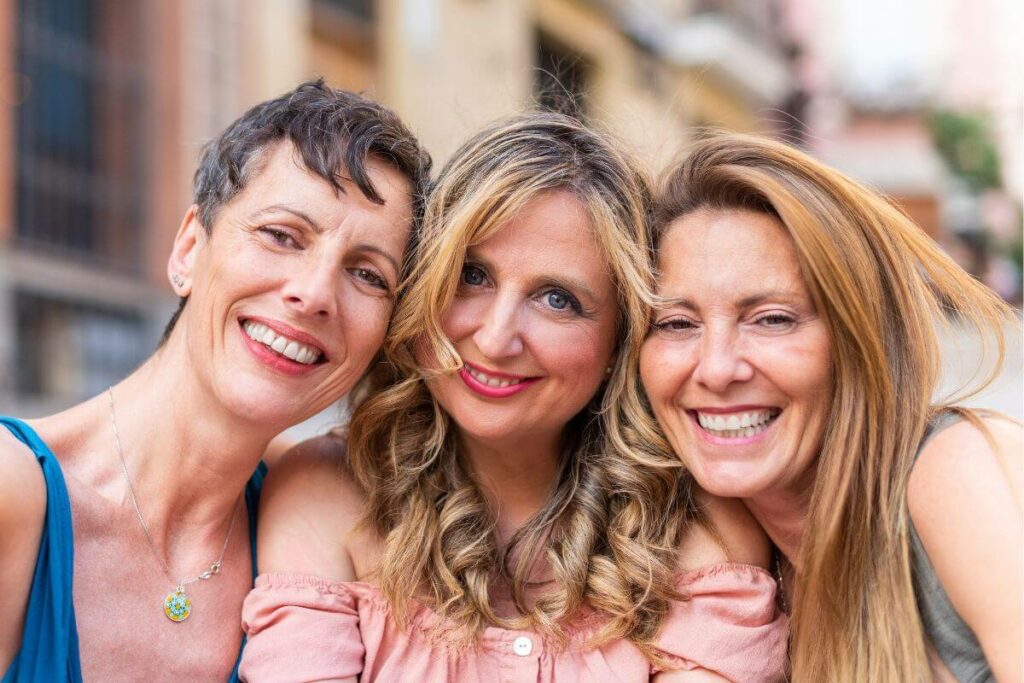 three middle aged women put their heads together for a fun selfie