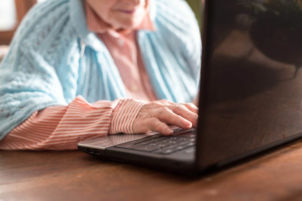 a senior woman learns how to use a laptop