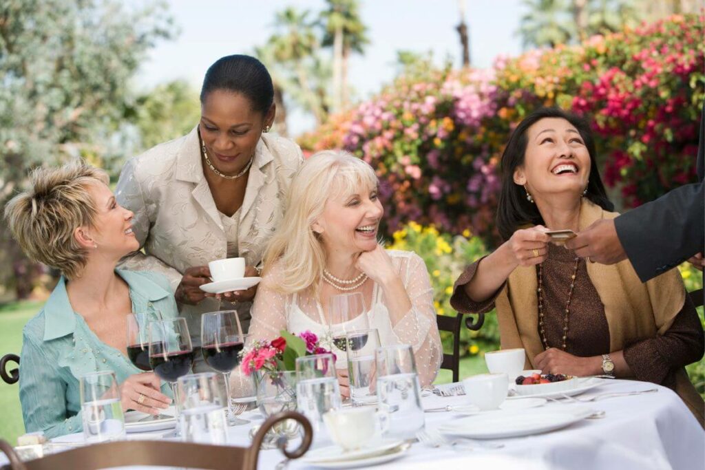 four girlfriends over 50 enjoy lunch together at a winery