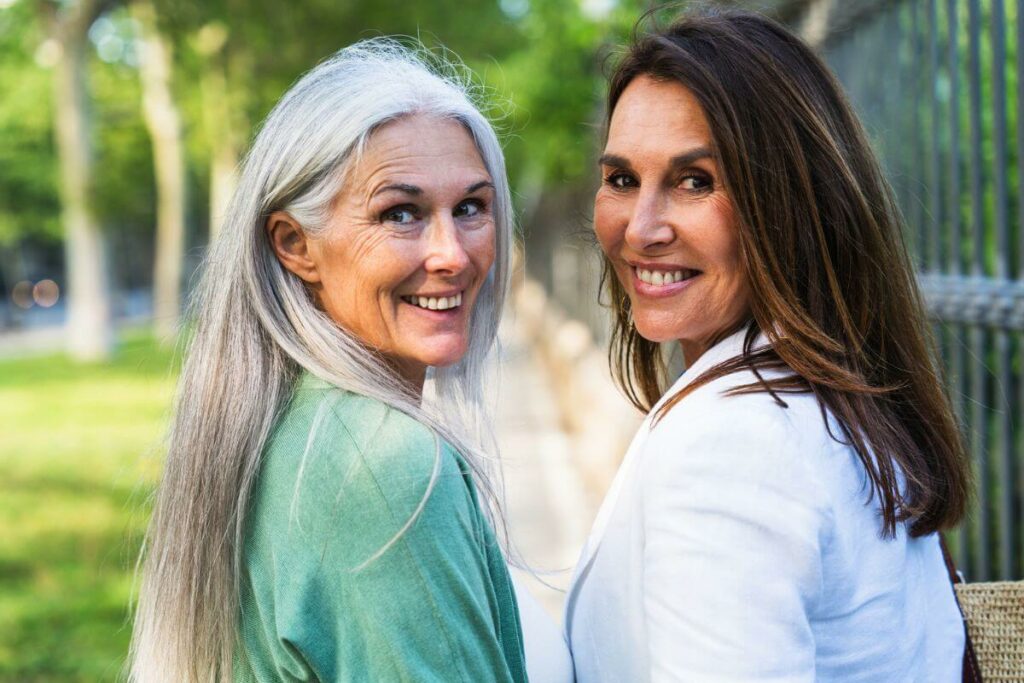 two attractive middle aged women dressed casually take a walk in the park