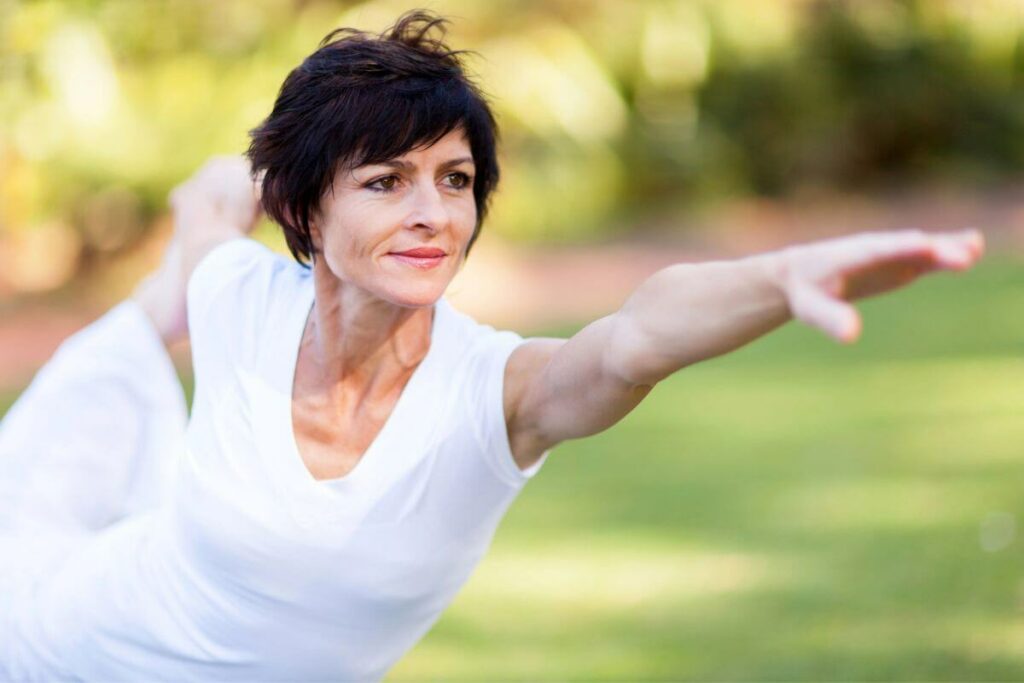 a middle aged woman rejects what not to wear after 50 by wearing plain white to do yoga in the park