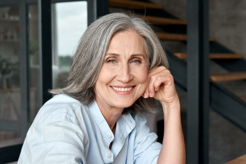 beautiful middle aged woman smiles at the camera confidently after she has read her favorite boss babe quotes