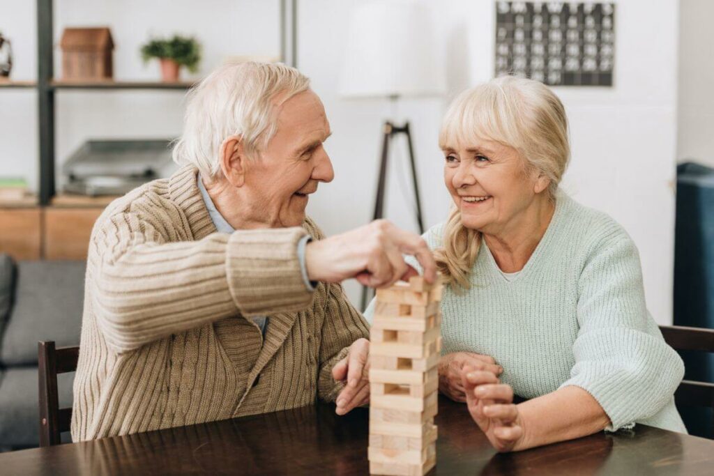 an elderly couple playing a table game together