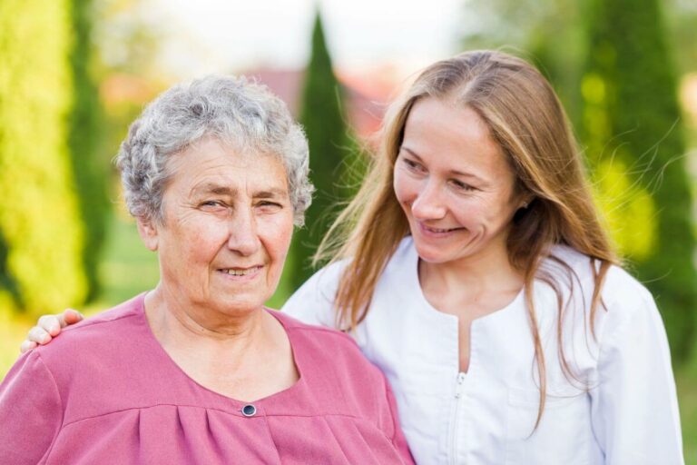 an adult woman uses tips about 7 things not to say to someone with dementia with her elderly mom as they walk happily together in the park