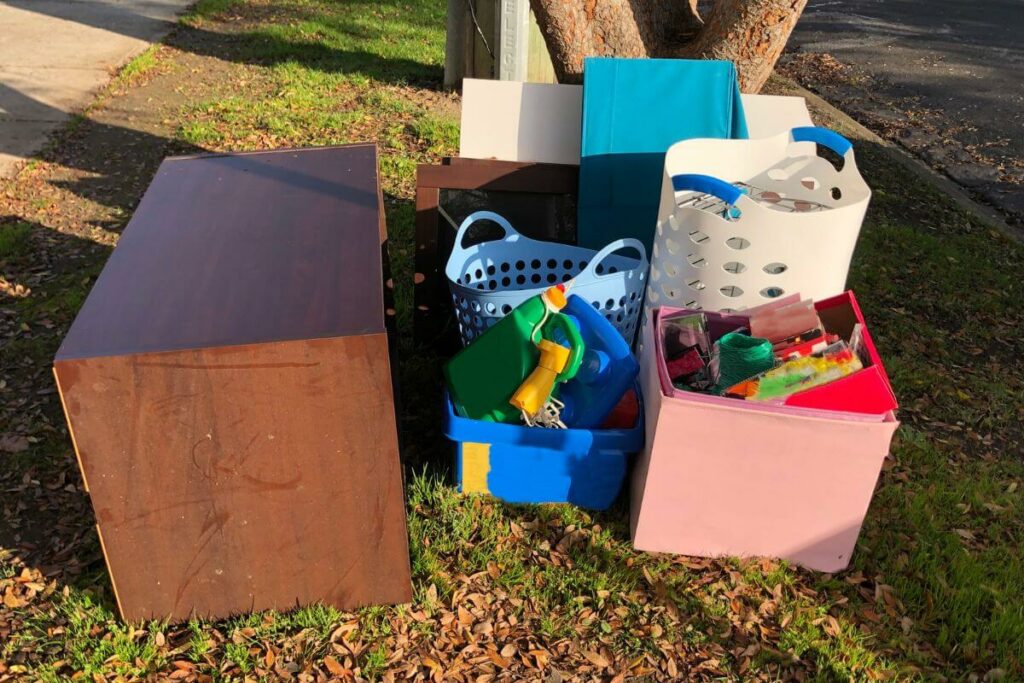 household items are put out on the curb for pickup after a family has been decluttering and downsizing for seniors who live in the house.