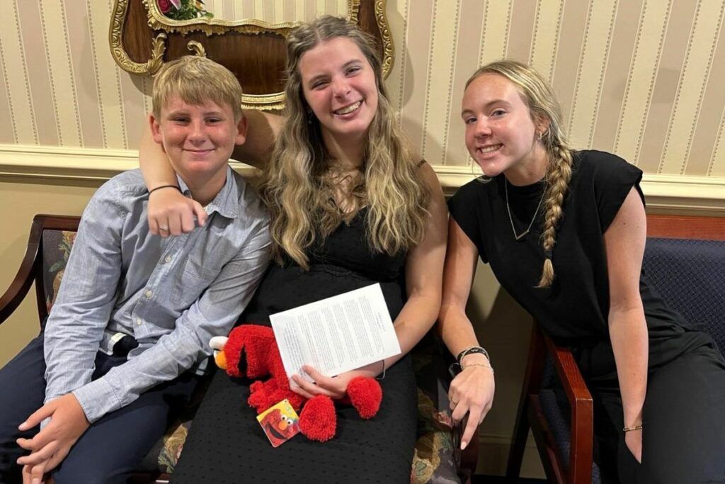 three teenage grandchildren smiling for the camera and goofing off