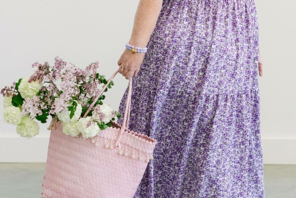 closeup of a woman carrying a bag of purple and white fragrant flowers