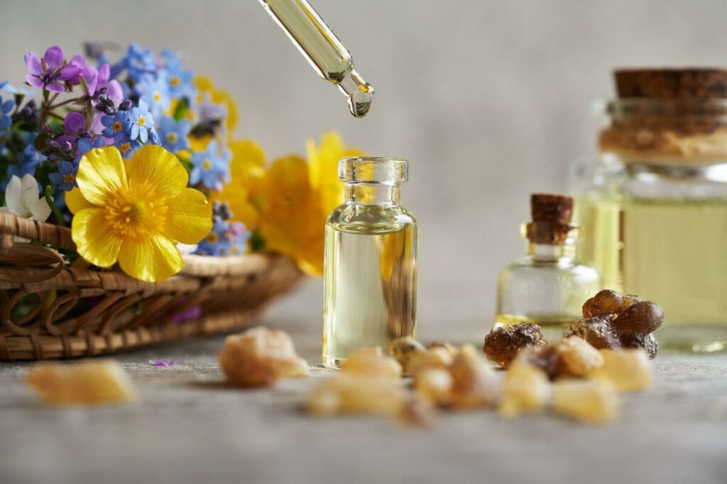 close up of three floral essential oil blends with a variety of flowers in the background