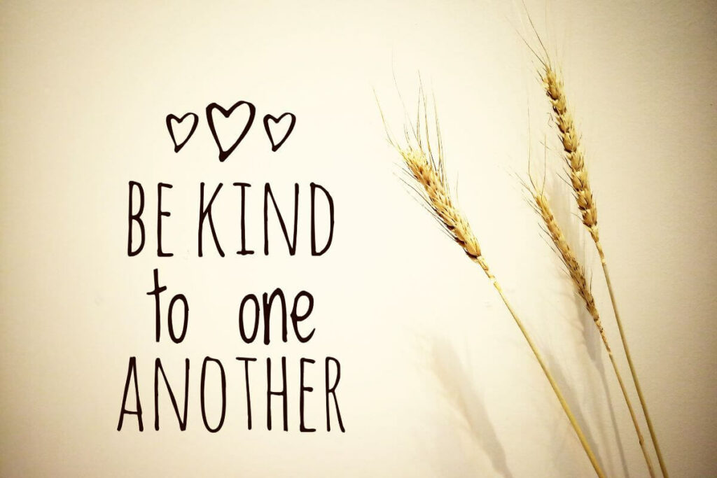 Be kind to one another quote with three little hearts and some wheat.