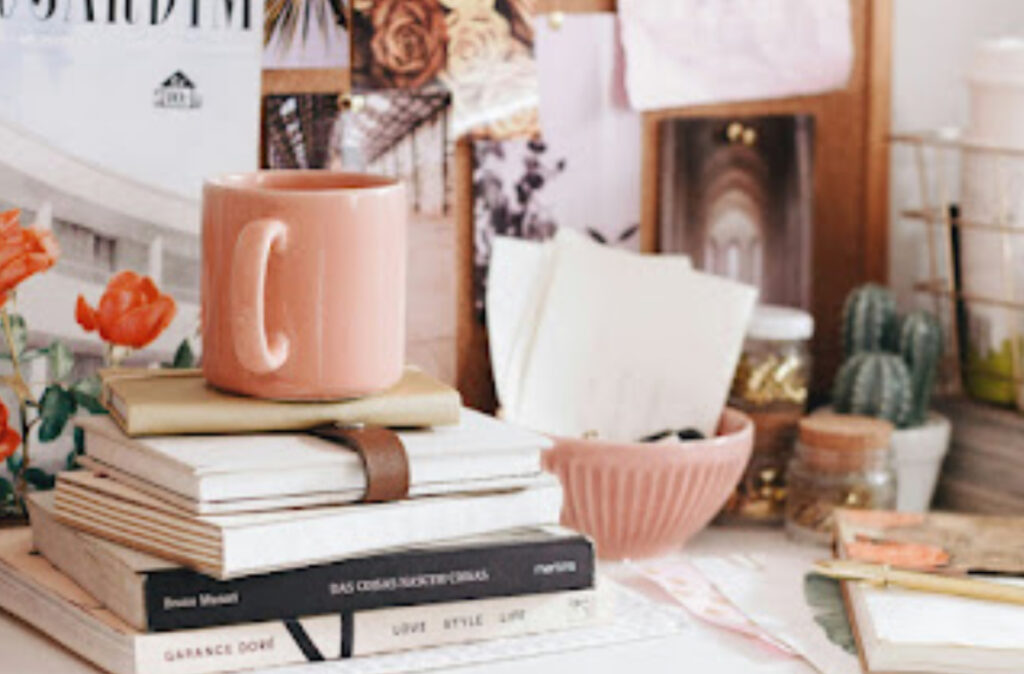 A busy workspace with books and desk materials in shades of peach for those who want to make the most of your side hustle.