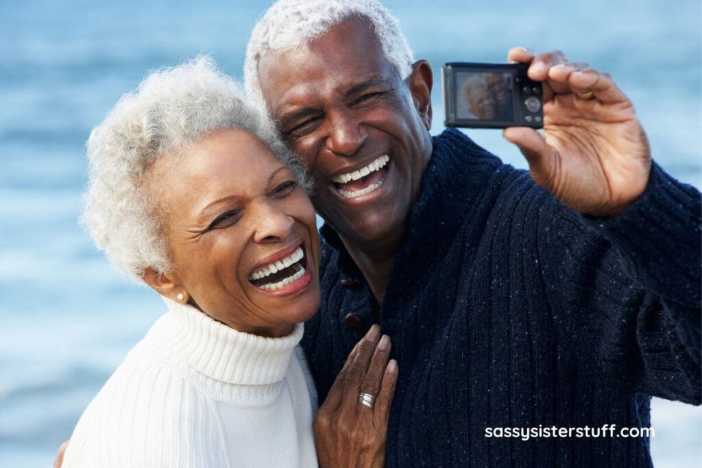 an elderly couple vacationing at the beach takes a selfie on the shore