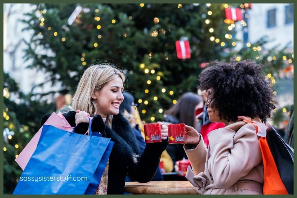 two friends meet at a street cafe for warm cocoa during a christmas shopping trip