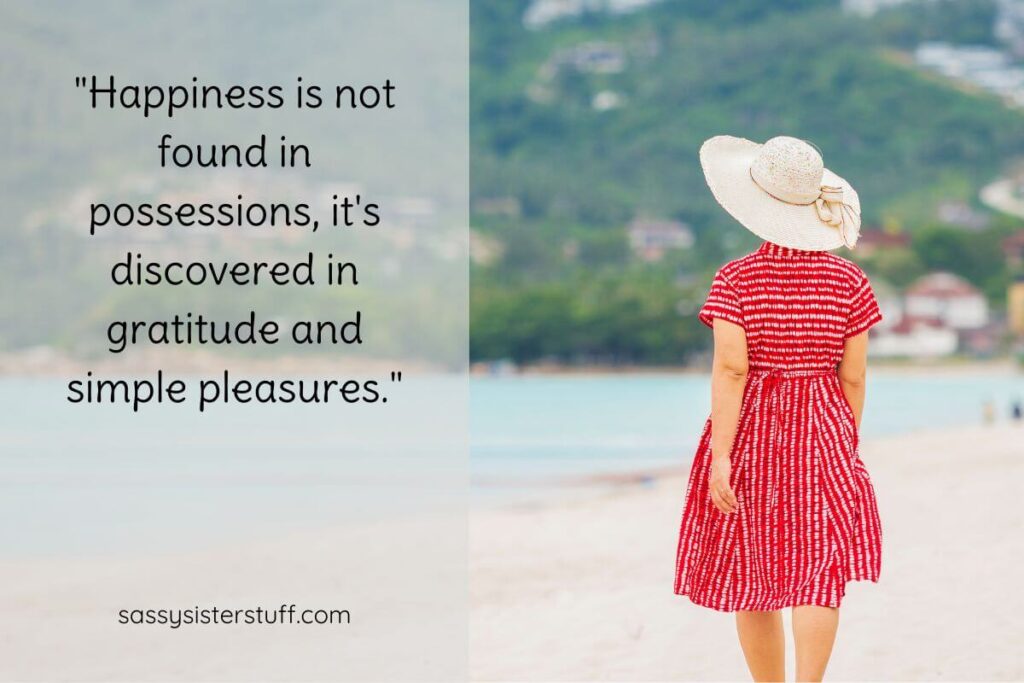 back of a woman walking on the beach in a resort town and a quote that says "Happiness is not found in possessions, it's discovered in gratitude and simple pleasures."