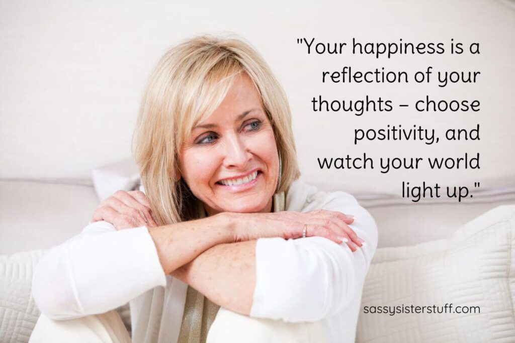 happy middle aged woman relaxing on a sofa ondering midlife, plus a "Your happiness is a reflection of your thoughts – choose positivity, and watch your world light up."