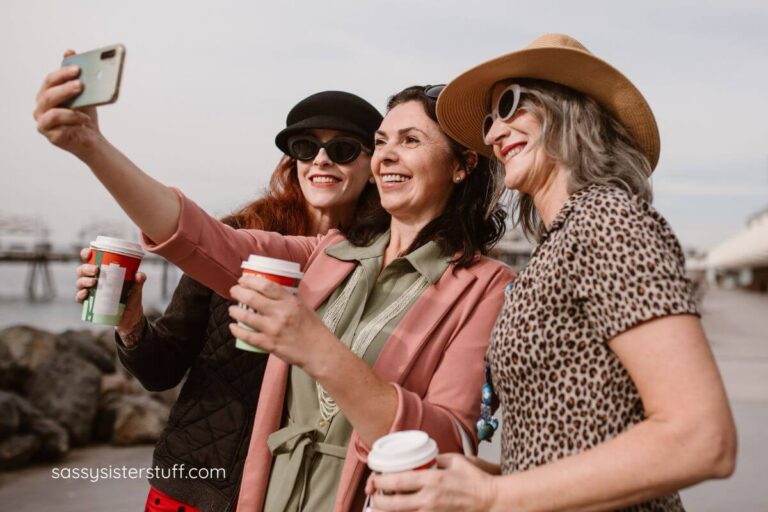 three middle aged women on a boardwalk take a selfie together; featured image for quotes for women in midlife