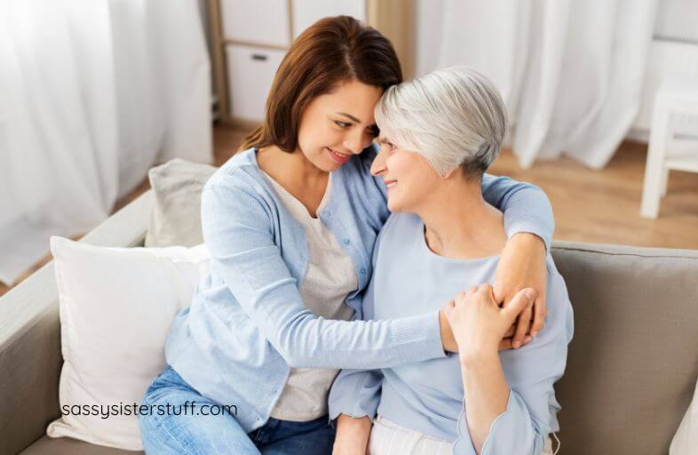 an adult female sits with her aging mom and has a loving conversation.