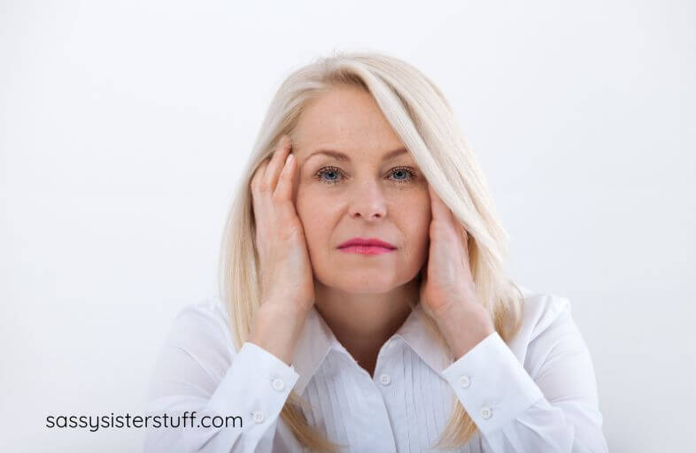 middle aged woman looking at the camera pondering bitterness jealousy and envy quotes that can help her let go of these negative emotions.