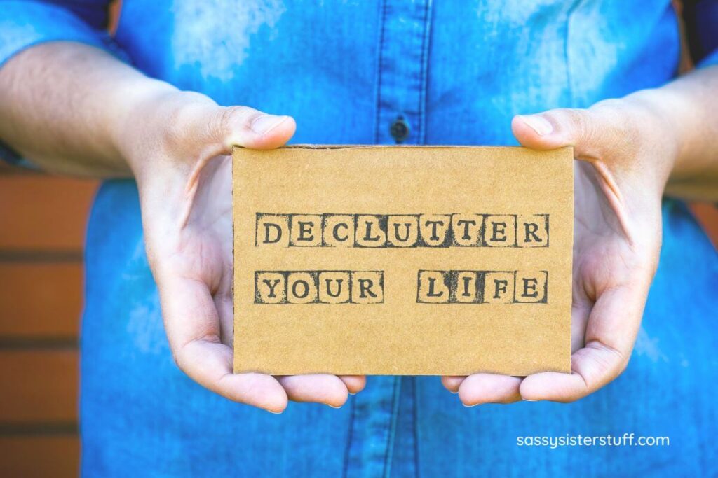 close up of a woman holding a block that says declutter your life.