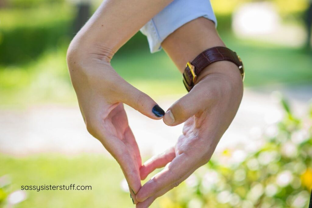 a male and female hand forming a heart.