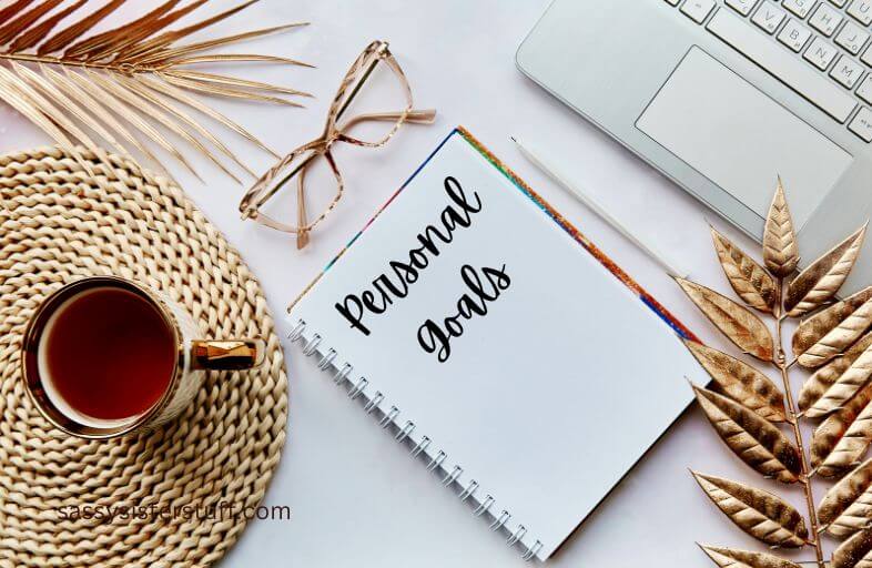 top view of a desktop with a journal that says personal goals.