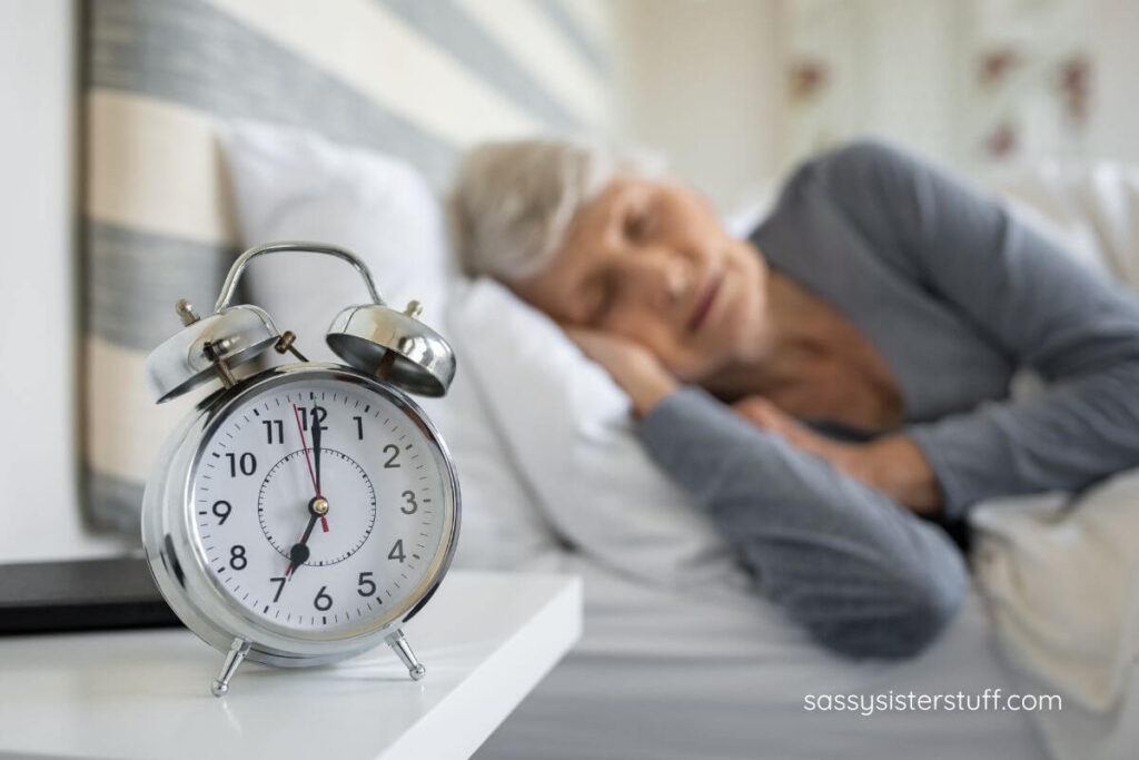 middle aged woman sleeping with her alarm clock set to go off at 7am.