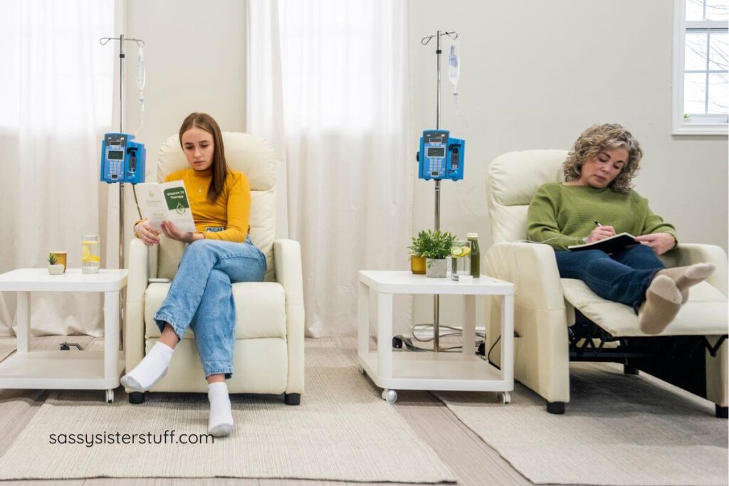 a middle aged woman and a young woman sit in a spa for vitamin IV drips.