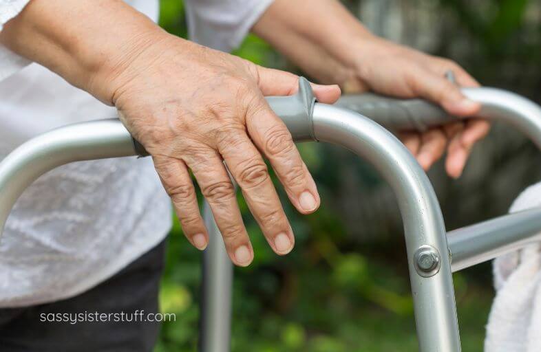 close up of an elderly parent's hands holding onto a walker for support