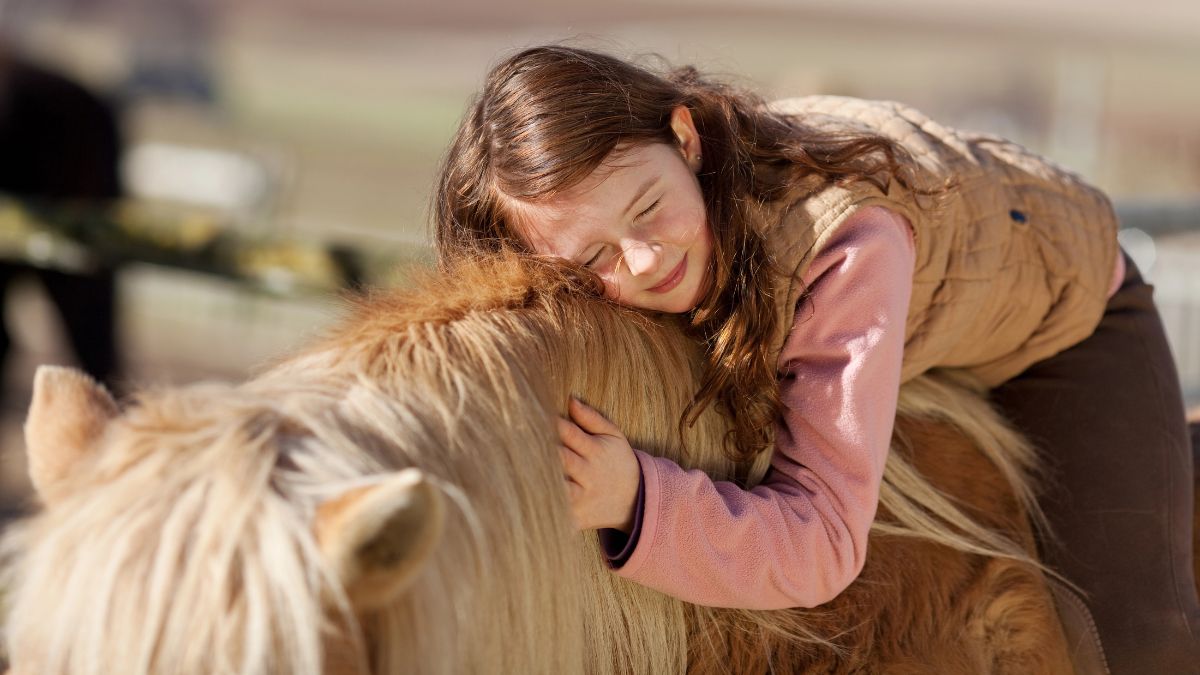 child hugging horse