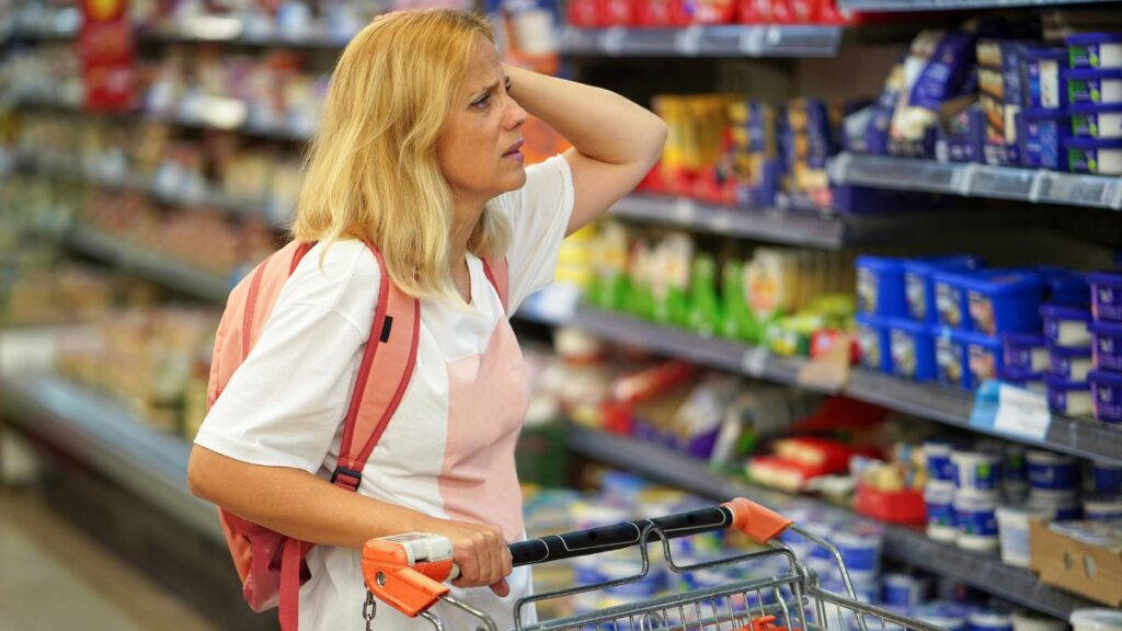 confused woman looking at items in grocery store