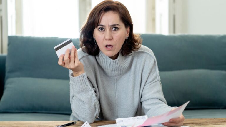 confused woman with bills and credit card