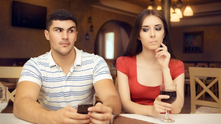 couple at dinner man on phone