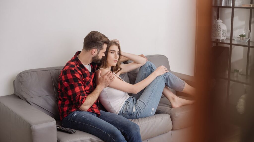 couple with woman looking annoyed on couch