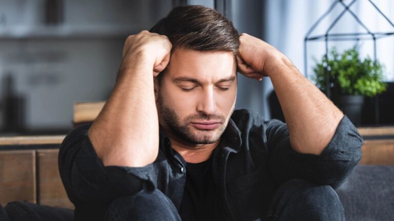 frustrated man sitting with hands on head