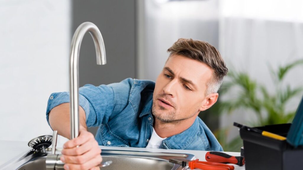 man fixing sink