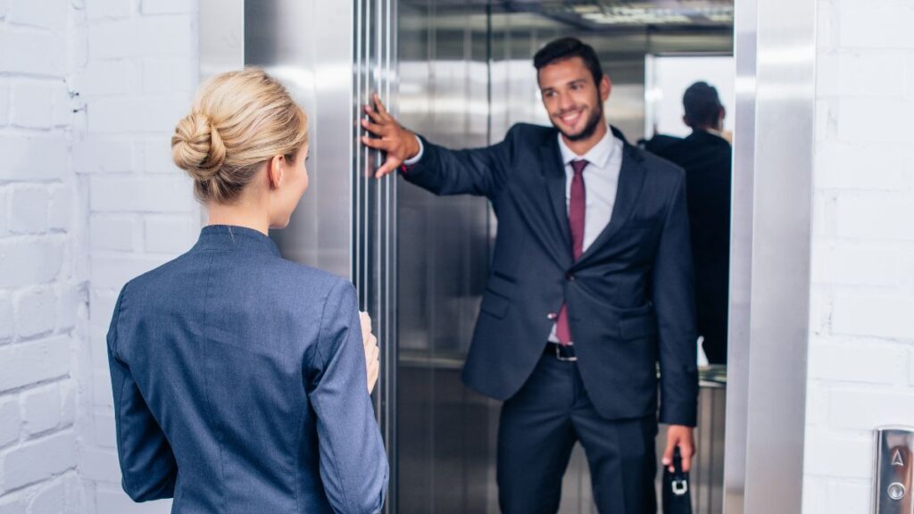 man holding elevator door for woman Igor