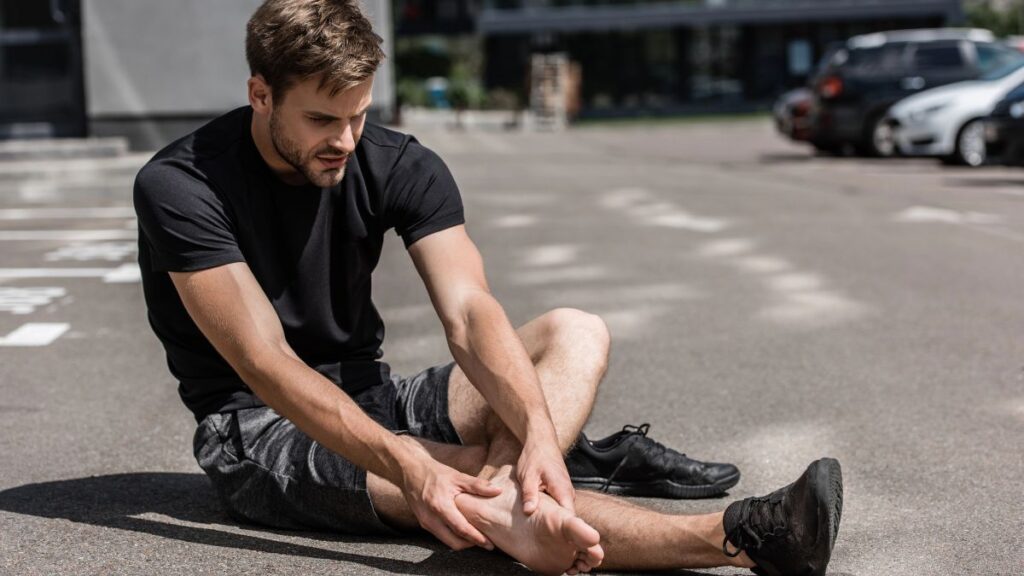 man in pain holding foot