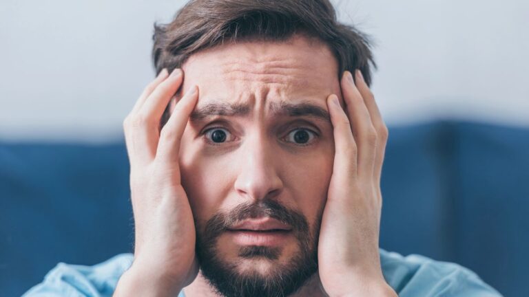 man looking stressed with hands on face