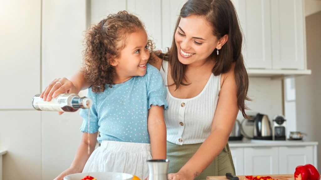 mom and daughter making salad in kitchen