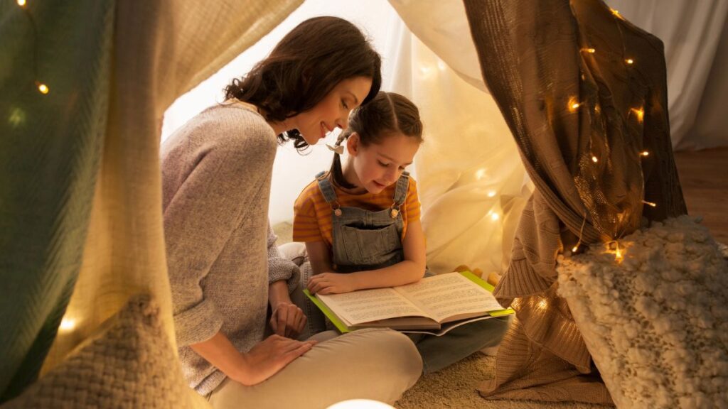 mom and daughter reading in tent