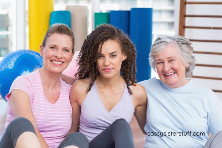 three female friends sit together after exercise class.