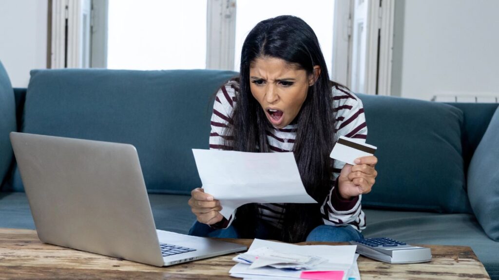 upset woman looking at credit card bill