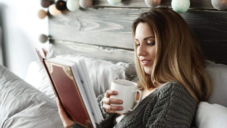 woman drinking coffee and reading a book