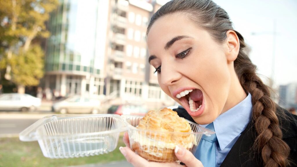 woman eating pastry outside