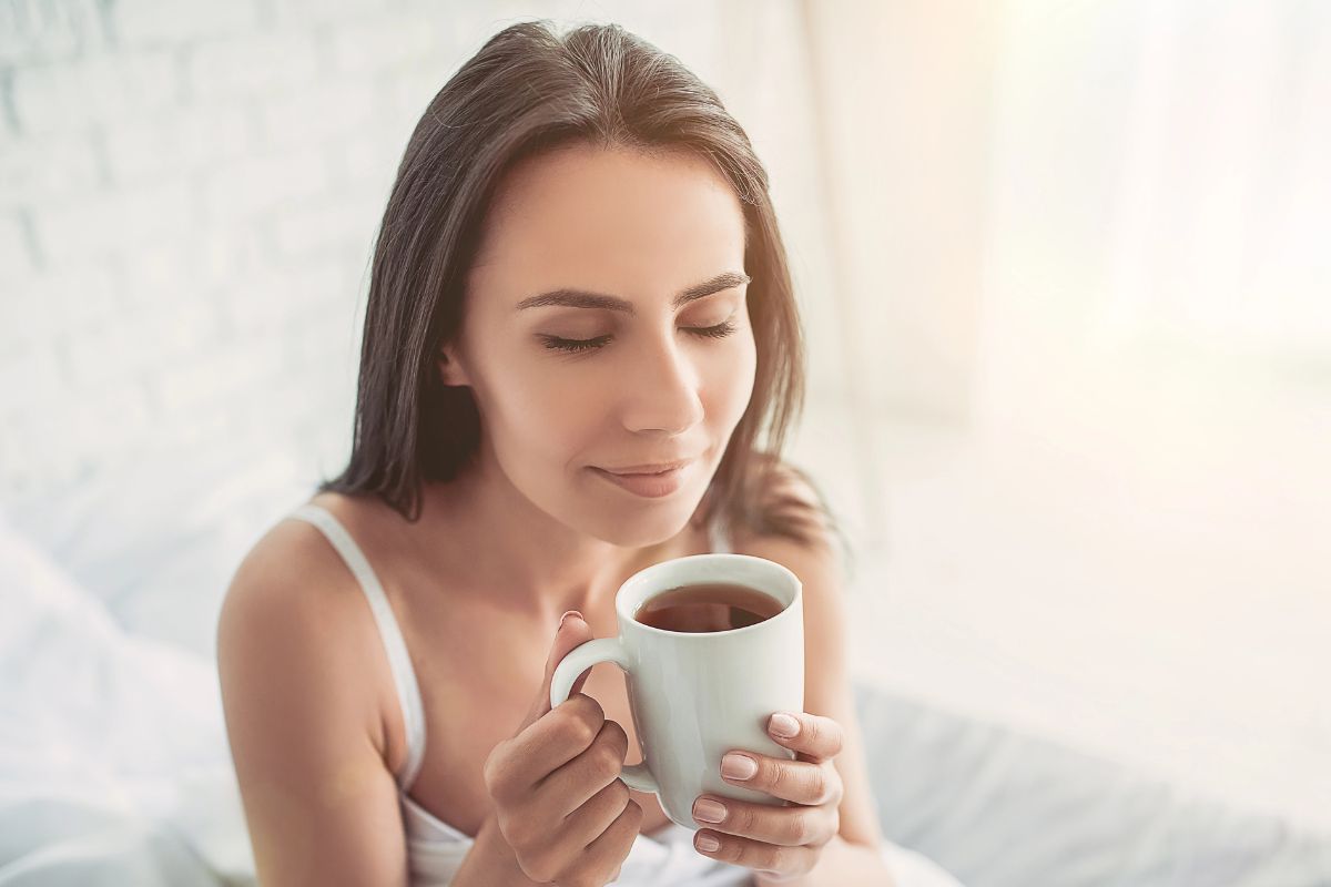 woman enjoying her coffee in bed