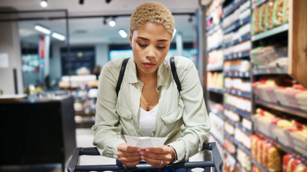 woman in grocery store looking at receipt