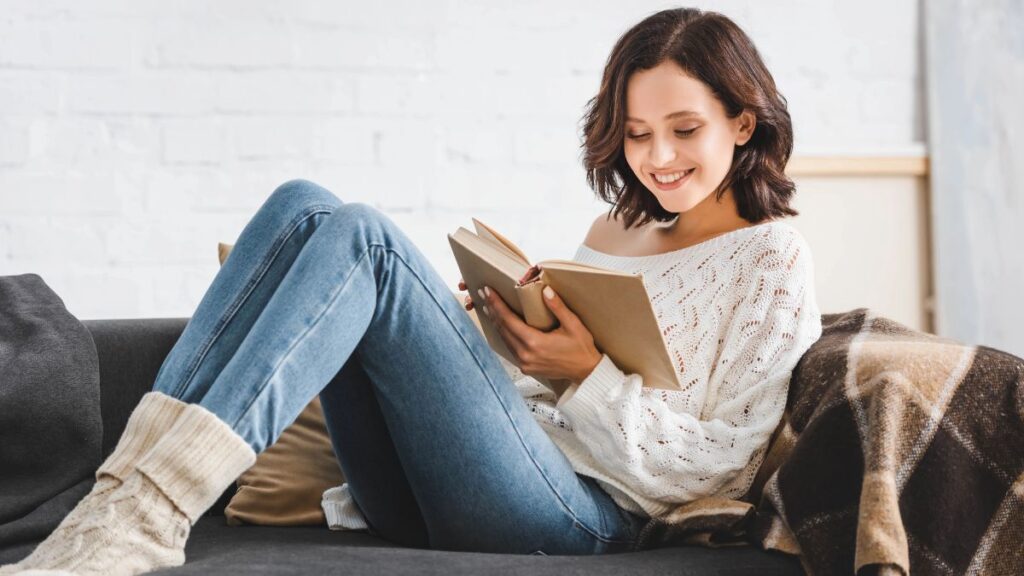 woman in white reading on couch