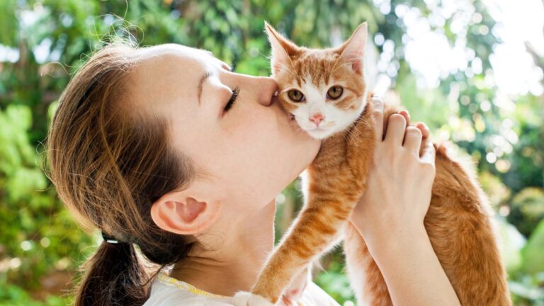 woman kissing cat